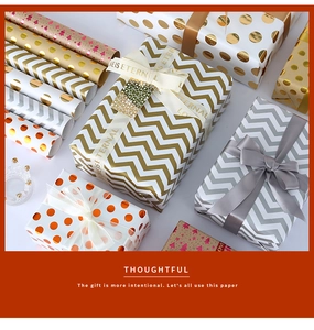 Macro view of patterned gift wrapping paper with metallic foil dots and wave designs