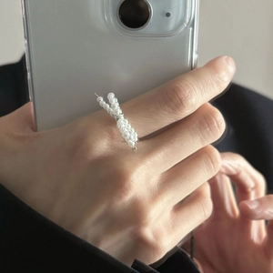 Close-up of a 925 sterling silver bow ring with small white pearls on a hand
