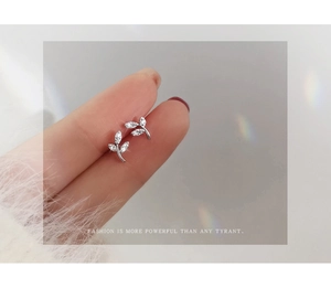 Detailed close-up of S999 sterling silver leaf stud earrings with sparkling cubic zirconia