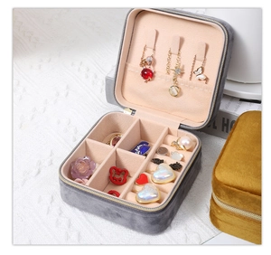 Gray square velvet jewelry organizer with gold zipper showing necklace hooks and interior