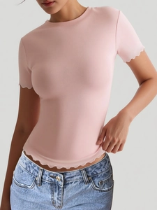 Detail of pink slim fit yoga T-shirt with ribbed fabric and wavy lettuce edge hems