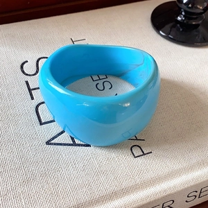 Thick bright blue resin bangle with subtle grey marble textures in a minimalist design