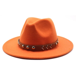 Détail du chapeau fedora en laine orange avec ruban en cuir et rivets métalliques