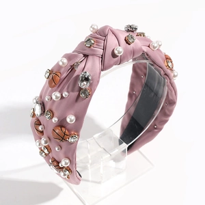Detailed view of pink knotted headband with pearls, rhinestones and basketball charms