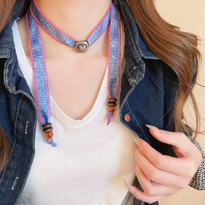 Close-up of denim choker necklace with pink stitching and heart pendant on a model