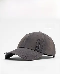 Détail d'une casquette en jean gris anthracite avec finitions usées et trous de style rétro