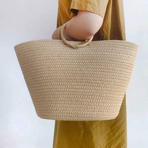 Large woven cotton rope beach tote with unique circular handles in a natural beige finish