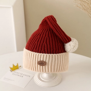 Detail view of winter baby knit hat featuring two-tone color block and white pom-pom