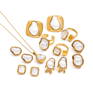 Golden baroque pearl jewelry set featuring necklace, rings and earrings on white background