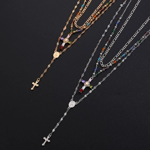 Detailed view of gold and silver layered rosary necklaces with colorful beads and cross pendant