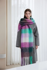 Detail of a thick winter scarf with colorful plaid pattern and elegant fringe edges