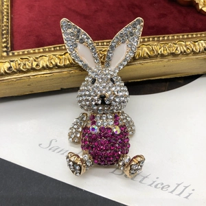 Close-up of rabbit brooch with purple crystals and white enamel on velvet background