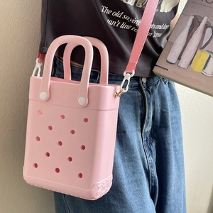 Pink EVA perforated tote bag shown on model with shoulder strap and white button details