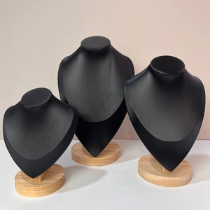 Three-piece black bust necklace display set with natural wooden bases for jewelry storage