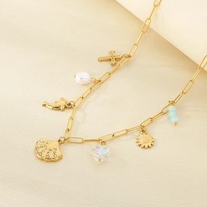 Detail of gold ocean-themed necklace featuring seashell, dolphin and pearl charms