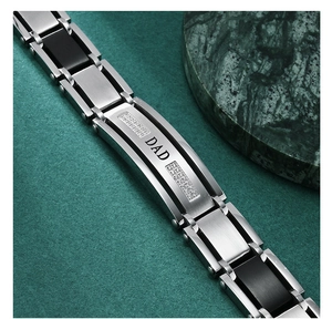 Detail of DAD inscribed watch band style bracelet with rhinestones and black metal