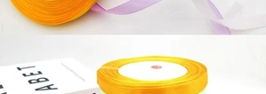 Detailed macro view of yellow, purple and white 1cm satin ribbon rolls for gift wrapping