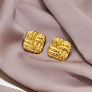 Golden square stud earrings with textured woven pattern and 18k gold plating on fabric