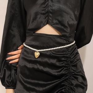 Chaîne de taille en perles blanches avec pendentif cœur doré sur robe en satin