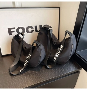 Detail view of two black nylon crescent bags showing different sizes and FASHION logo straps