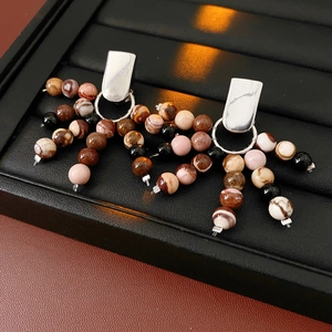 Detail of silver drop earrings with multi-colored stone beads and elegant fringe accents