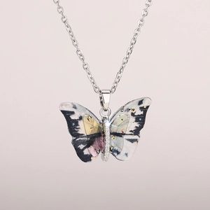 Detail of butterfly pendant with black and white artistic paint and sparkling crystals