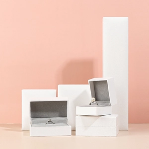White textured leatherette jewelry gift boxes for rings and necklaces on a pink background