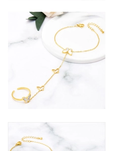 Détail d'un ensemble bracelet bague papillon doré avec incrustation de nacre sur marbre