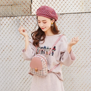 Dettaglio mini zaino in pelle rosa e tessuto a quadri con chiusura in metallo