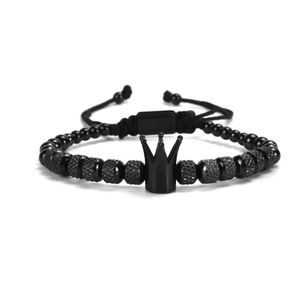 Macro detail of men's crown bracelet showing matte black beads and adjustable rope