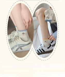 Close-up of cute puppy embroidery on cream-colored speckled socks with ribbed cuffs