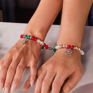 Detail of magnetic Christmas couple bracelets with tree and snowflake charms on wrist
