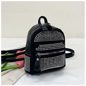 Detalle de mochila negra con diamantes de imitación, cremallera plateada y flores