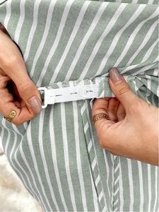 Detail of adjustable elastic waistband with button on striped maternity shorts fabric