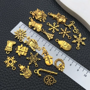 Macro detail of assorted Christmas charms on black leather with size scale reference