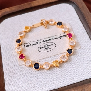 Macro detail of 18K gold plated vintage bracelet with colorful gemstones and toggle clasp