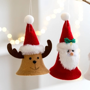 Handmade Santa and Reindeer Christmas bell ornaments hanging on a festive tree with lights