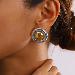 Détail de boucles d'oreilles bicolores rondes minimalistes en argent poli et plaqué or