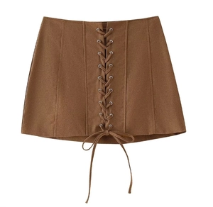 Detailed view of brown faux suede mini skirt featuring lace-up front and silver eyelets