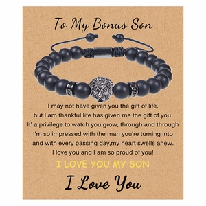 Detail of matte black beads bracelet with silver lion head on a kraft gift card