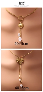 Detail of layered gold necklaces with shell, bow charms, and baroque pearls, 40+5cm length