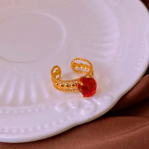 Vintage gold open ring with oval red zircon and intricate hollowed lace edge design