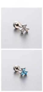Macro detail of screw-back tragus earrings with three-stone zircon cluster design