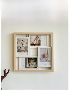 Detail view of multi-frame wooden wall decor with four 4x6in photo slots on white wall
