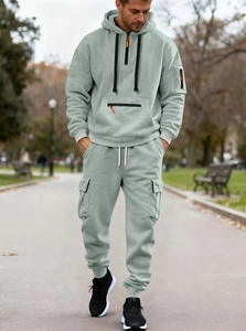 Detail of grey men's tracksuit featuring half-zip hoodie and cargo joggers in outdoor park