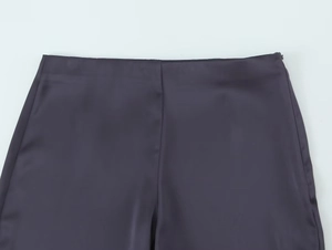 Détail de la taille du pantalon en satin violet foncé avec texture de soie et zip invisible