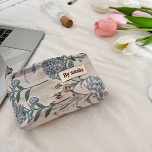Detailed macro view of French floral embossed fabric and silver zipper on makeup bag