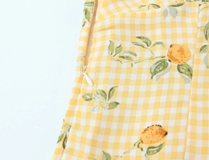 Dettaglio del vestito a quadretti gialli con stampe di limoni e zip invisibile