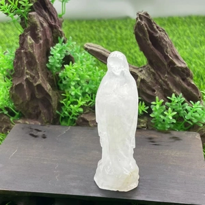 Detailed close-up of 10cm hand-carved clear crystal Virgin Mary statue on a wood base