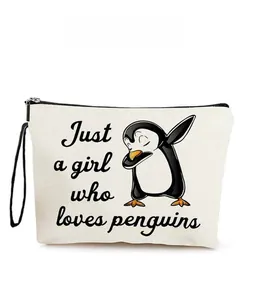 Detail of penguin print makeup bag with zipper closure and durable canvas fabric